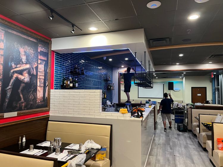 Final adjustments are being made to the bar area, which now features elegant blue tiles and overhead storage.