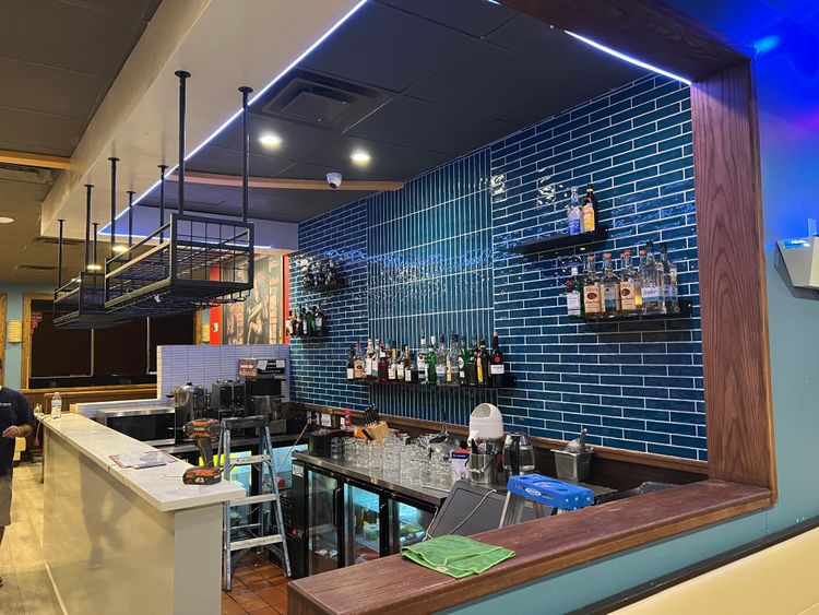 The bar is now fully equipped and stocked, ready to serve with its stylish blue tiled backdrop.