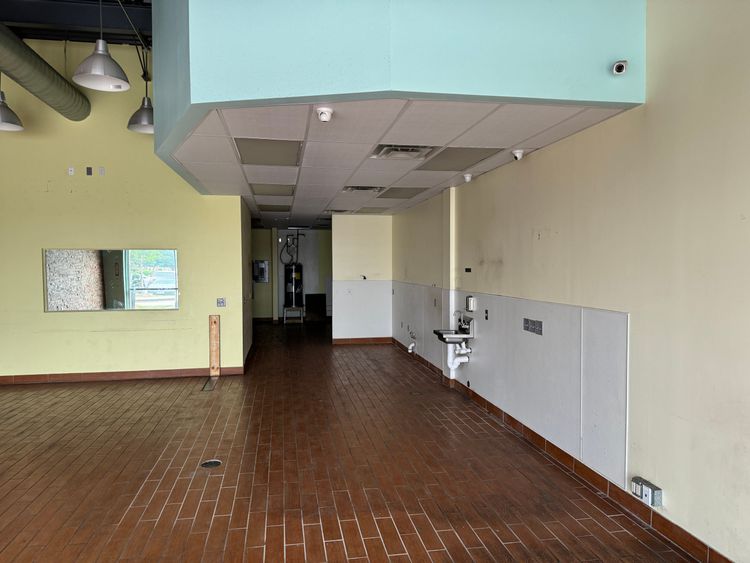 This commercial interior showcases a brown tiled floor and a distinctive light green bulkhead, ready for customization.