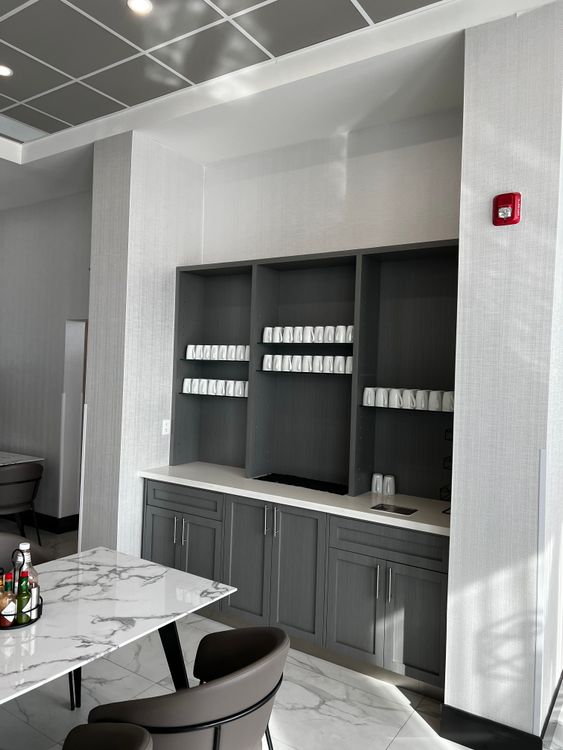 This functional and minimalist space features practical open shelving and a sleek white countertop.