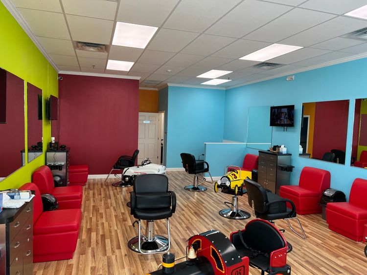 A completed salon interior showcases vibrant lime green, magenta, and blue walls with multiple styling stations.