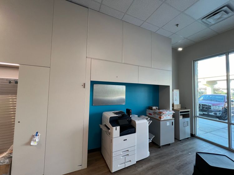A functional printing area featuring several professional-grade copy machines and a bright blue accent wall.
